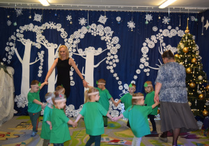 Dzieci z grupy Biedronki, przebrane za choineczki, tańczą.